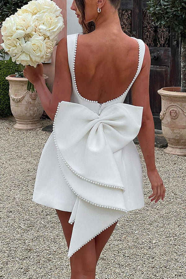 Lillian® | Stylish slim-fit mini dress with a large bow and beaded detailing